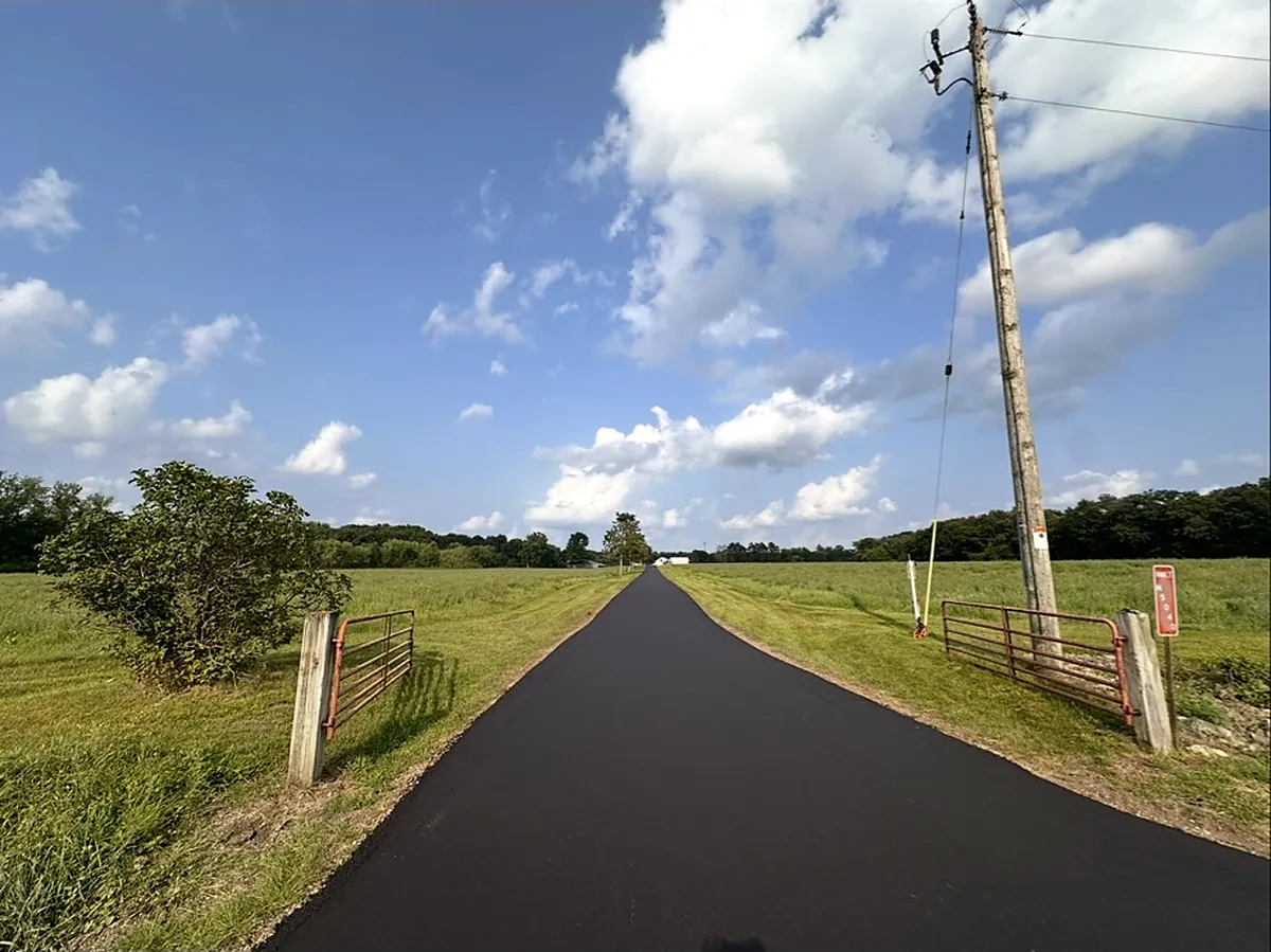Fresh driveway running between fence posts out to the pasture