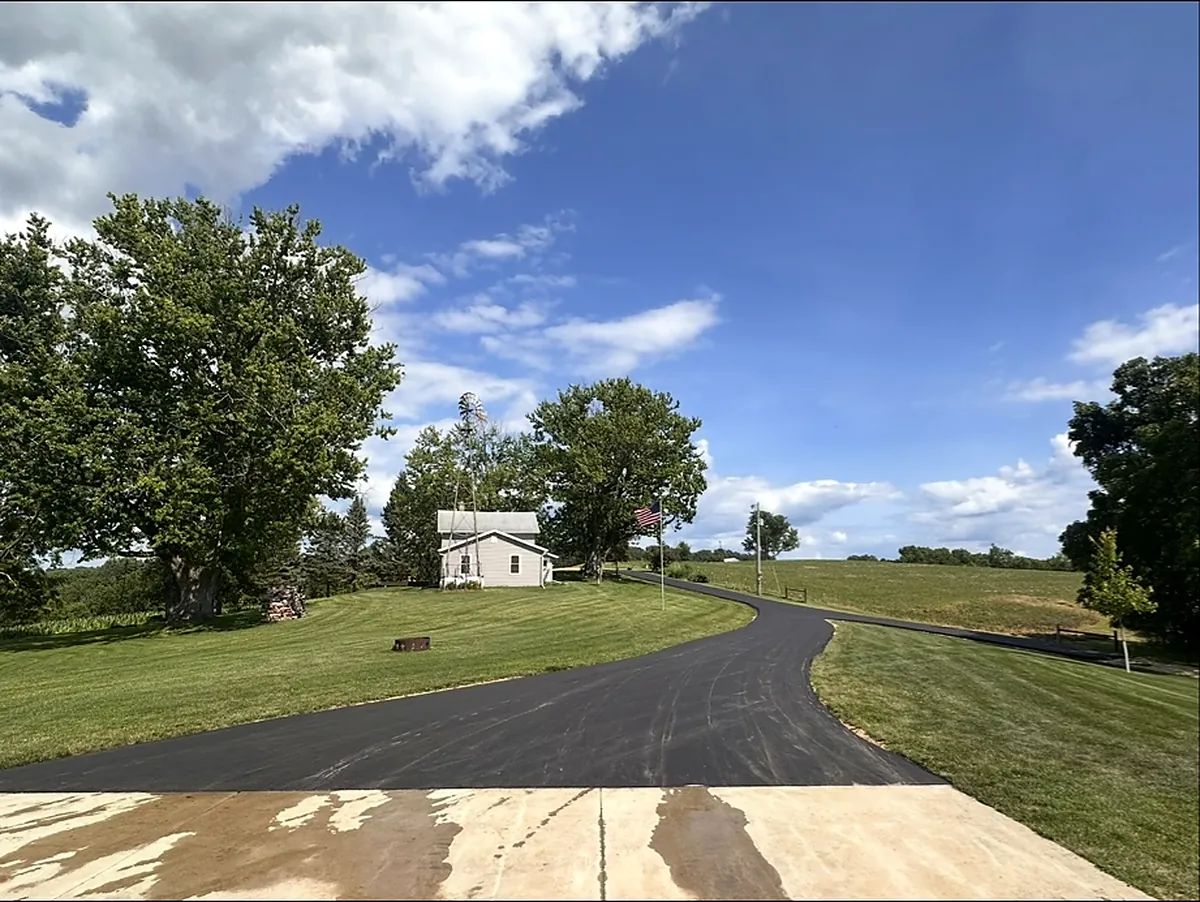 Drive sweeping up the hill toward a white farmhouse