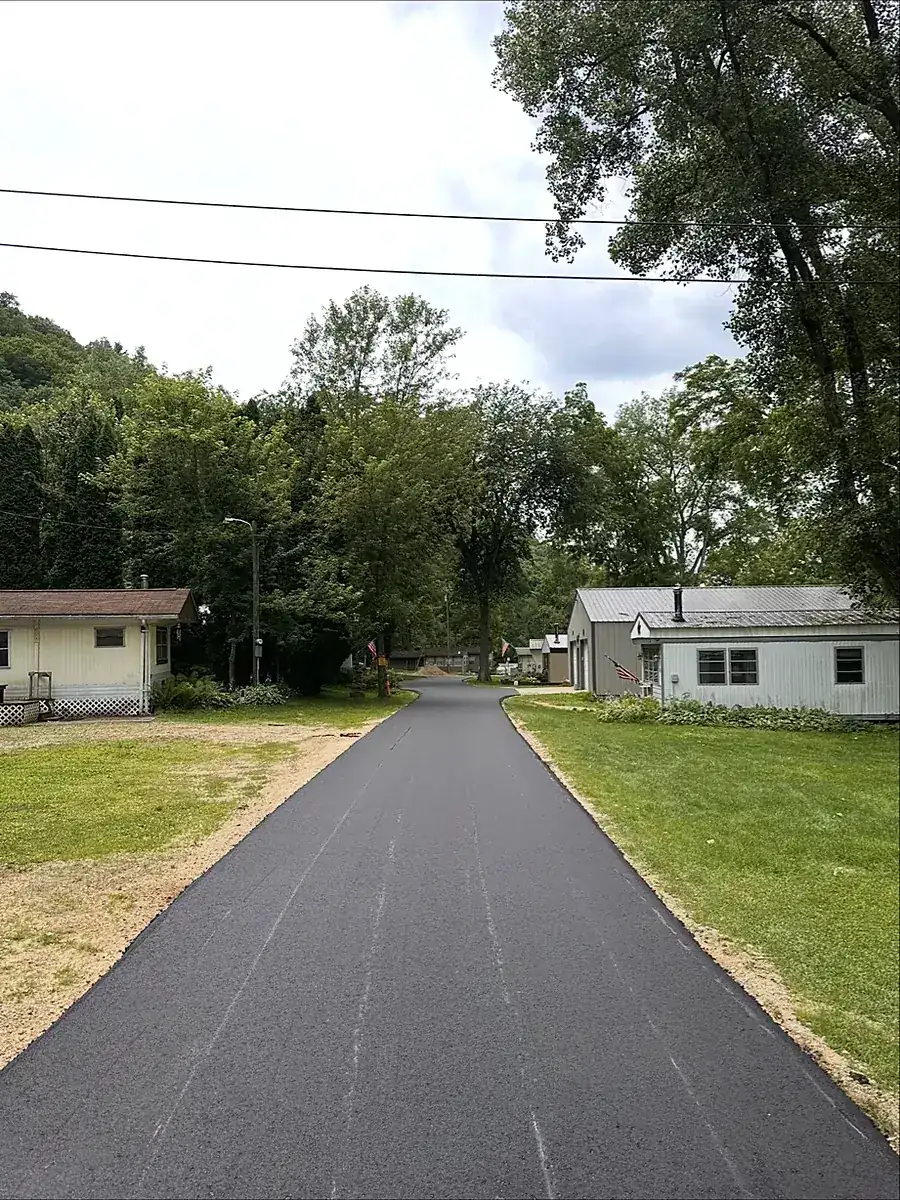 Straight drive between houses in a shaded valley