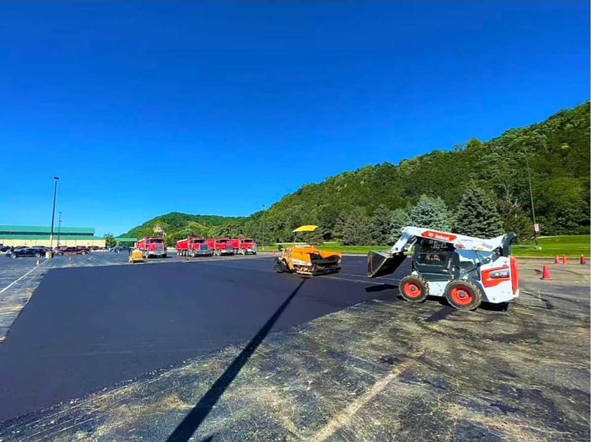 Crew running a skid loader on a large commercial lot