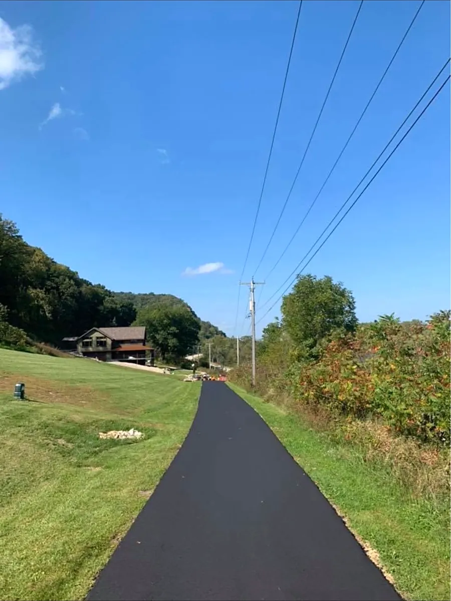 Long lane running along the hillside to a house in the trees