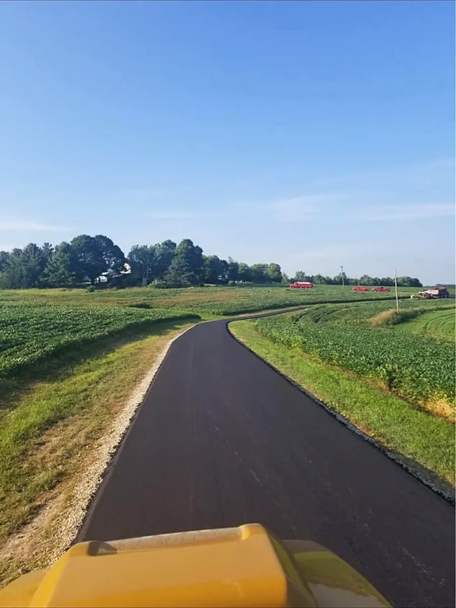 Lane paved along the edge of a cornfield