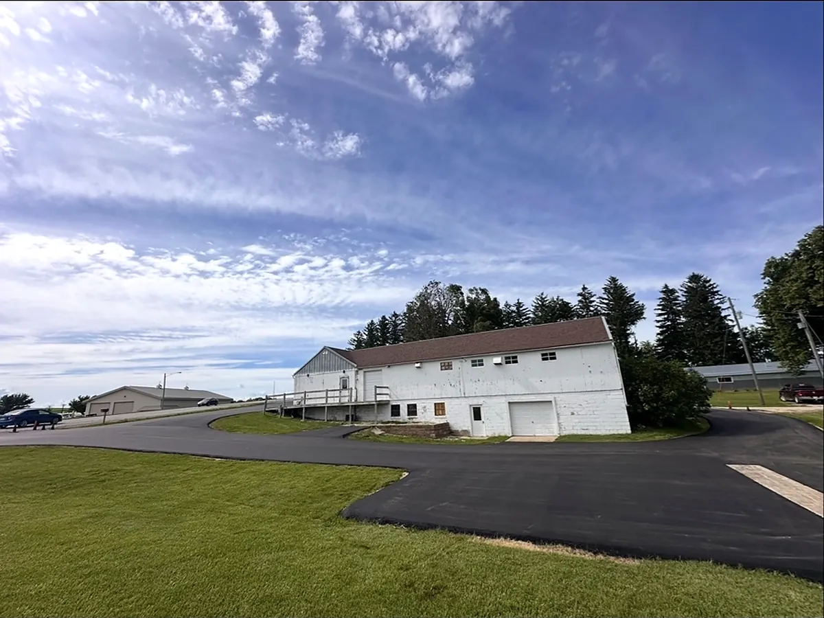 New lot in front of a white dairy barn