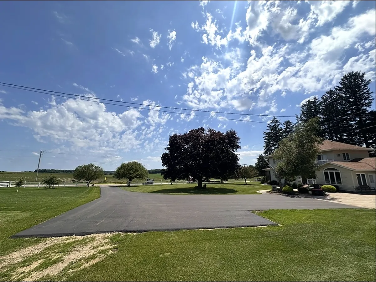 Drive looping in front of a two-story farmhouse