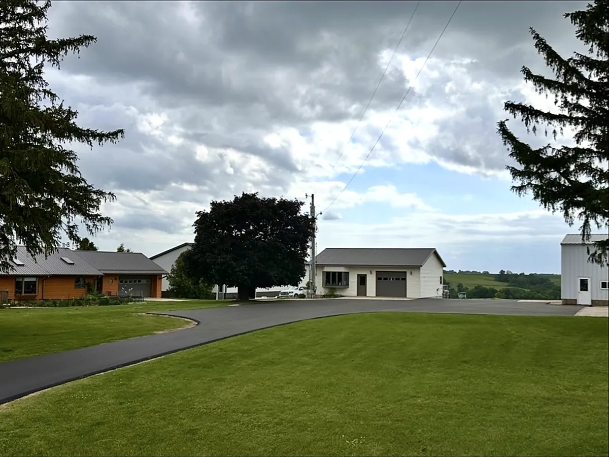 Drive crossing the lawn to a farmhouse and outbuildings